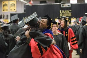 two women hugging at graduation ceremony